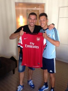 Özil sujeta la camiseta del Arsenal con su nuevo compañero, Lukas Podolsky.